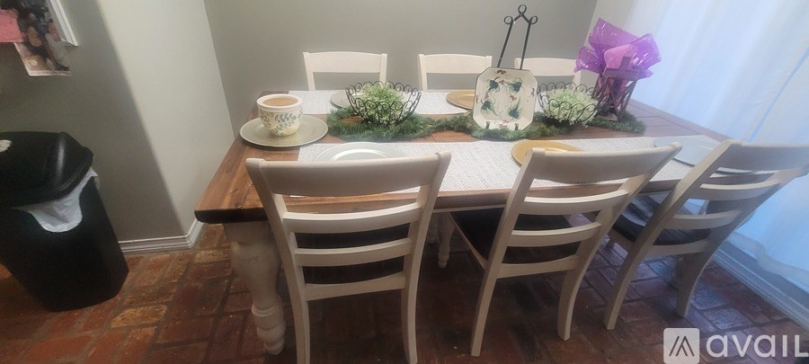 A dining table with chairs and a vase of flowers.