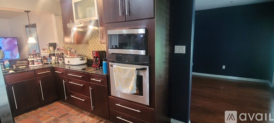 A kitchen with dark wood cabinets and a tile backsplash.