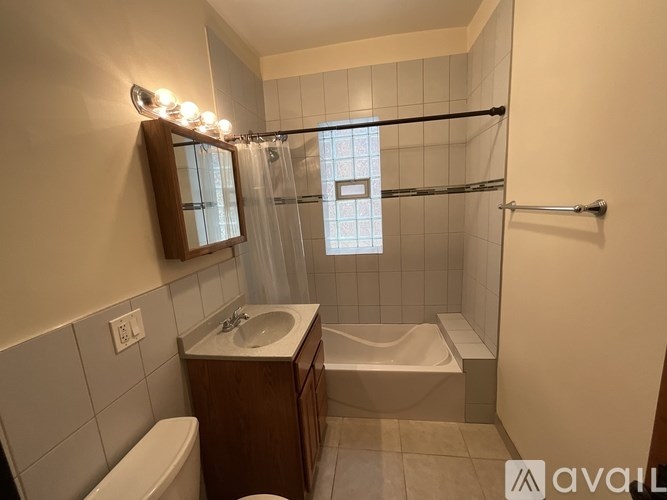 A bathroom with a white tub, sink, and toilet.