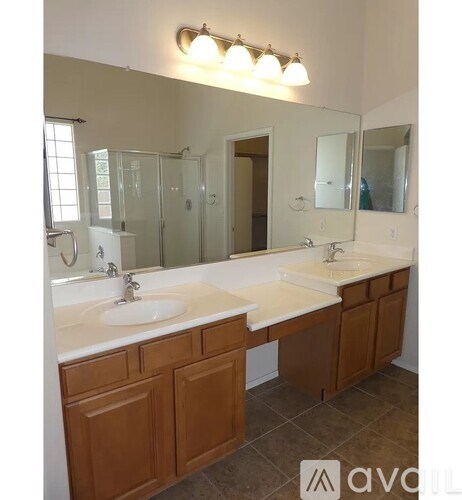 A bathroom with two sinks and a large mirror.