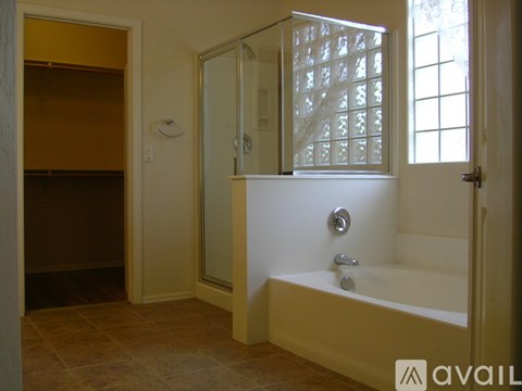 A bathroom with a tub, shower, and a window.