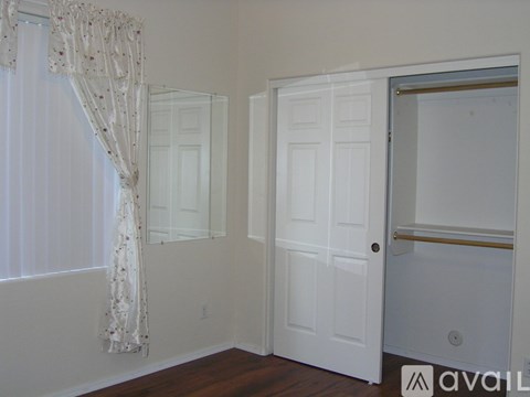 A room with a white door and a window with curtains.