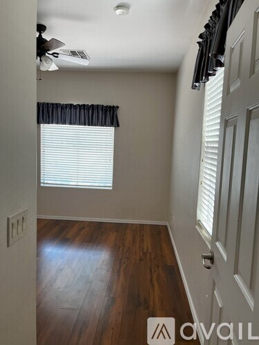 A hallway with a fan and closed white door.