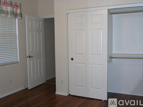 A white door is in a room with a window and a wall.