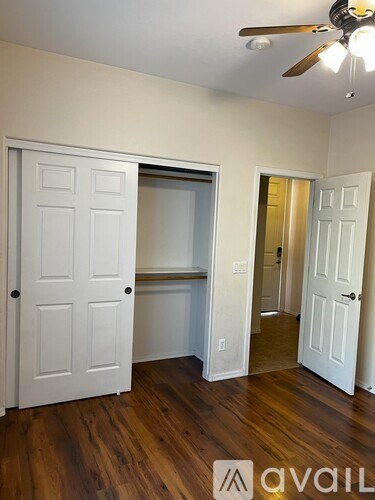 A room with a white door and a wooden floor.