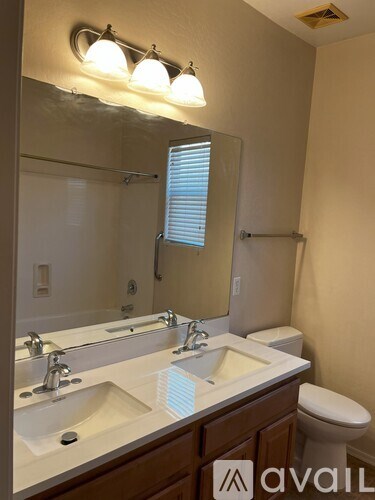 A bathroom with a sink, mirror, and toilet.