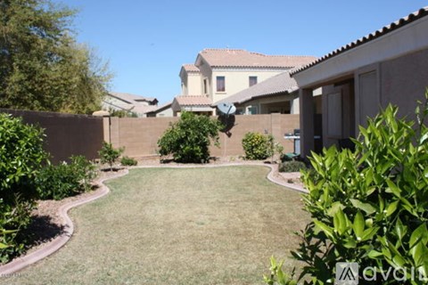 A backyard with a lawn and a house in the background.