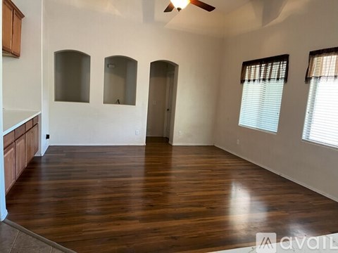 A room with wooden floors and a ceiling fan.