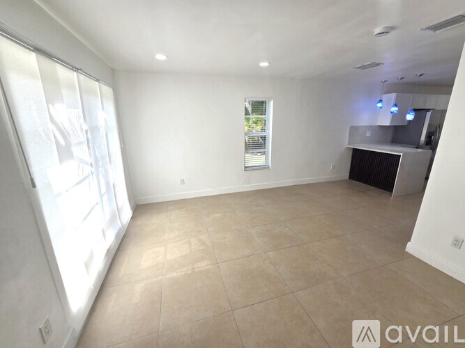 A spacious room with a ceiling fan and tiled floor.