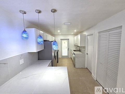 A kitchen with wooden cabinets and a marble countertop.