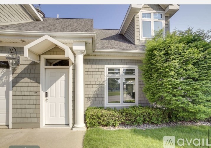 A house with a white door and windows is for sale.