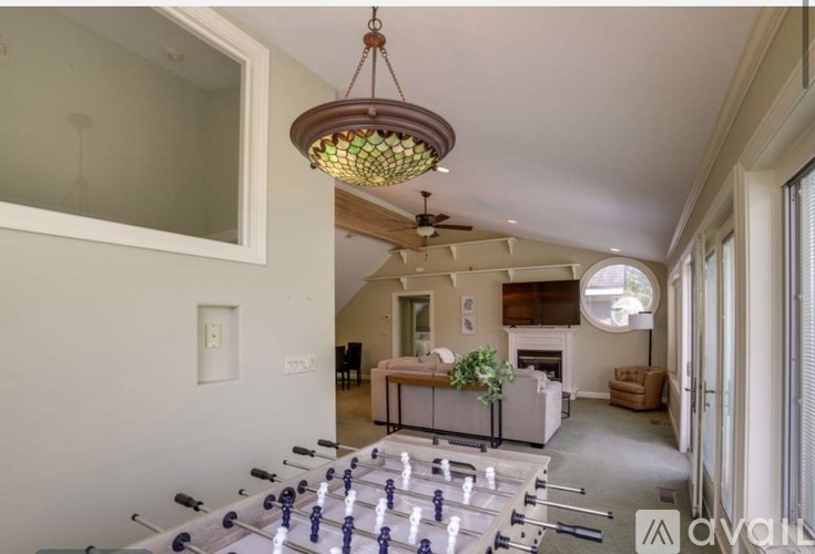 A living room with a foosball table in the foreground.