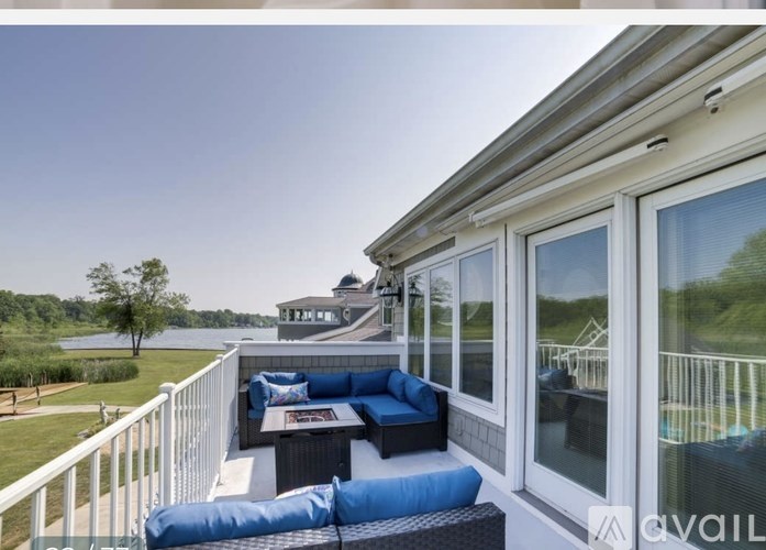 A balcony with a blue couch and a table with a magazine on it.