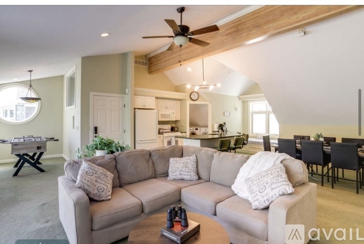 A living room with a couch, a coffee table, and a dining table.