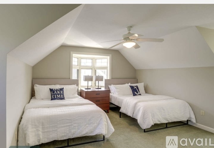 Two white bedrooms with a window and a ceiling fan.