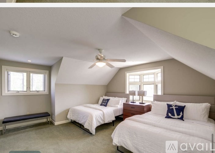 A bedroom with two beds and a ceiling fan.
