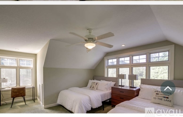 A bedroom with two beds and a ceiling fan.