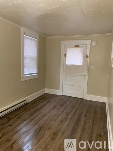 A room with wooden floors and a white door.