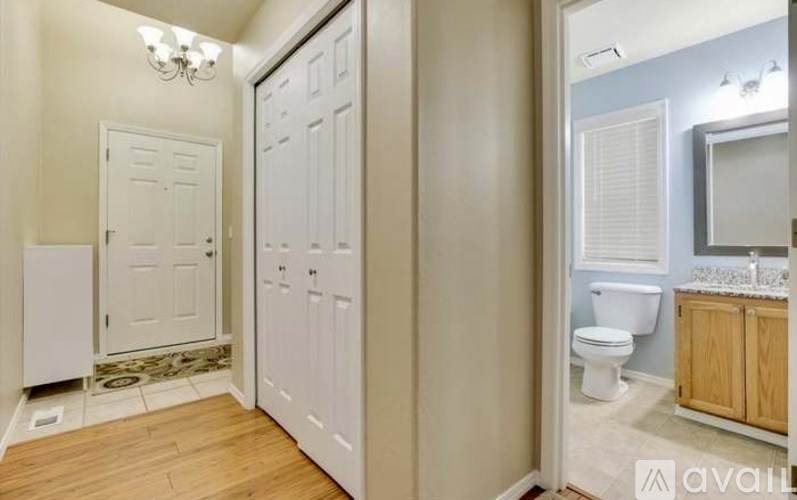 A bathroom with a toilet, sink, and a chandelier.