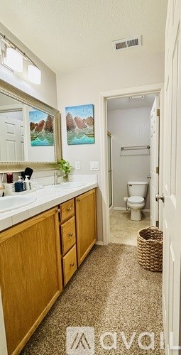 A bathroom with a toilet, sink, and mirror.