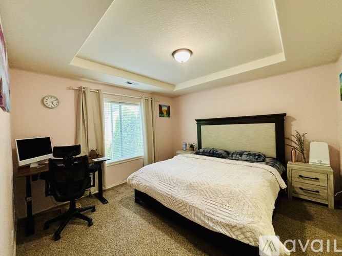 A bedroom with a bed, desk, and chair.