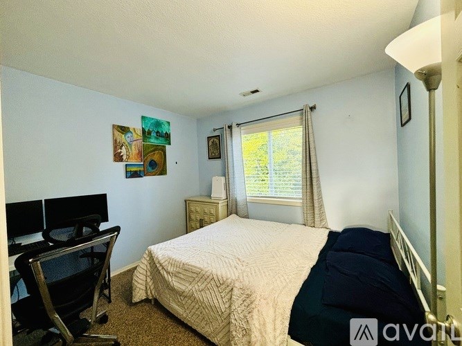 A bedroom with a bed, desk, and chair.