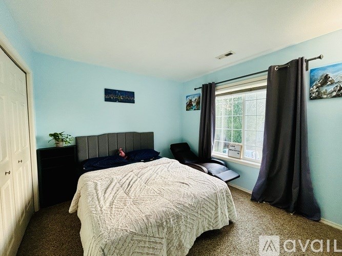 A bedroom with a bed, nightstand, and window.
