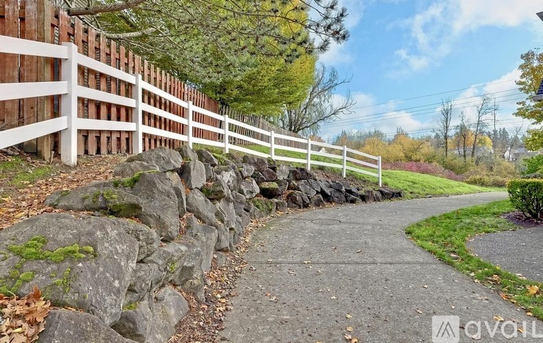 A white fence borders a rocky path.