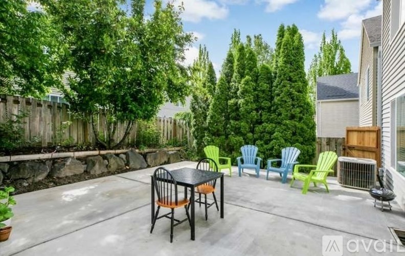 A patio with a table and chairs surrounded by trees.