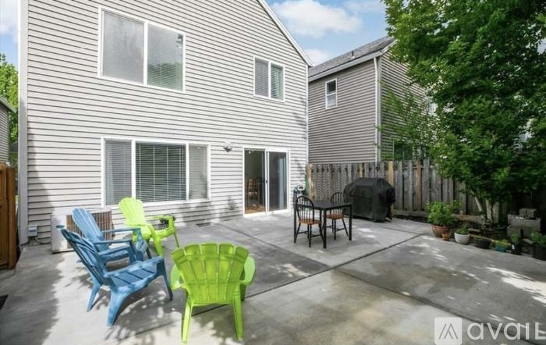 A patio with a table and chairs is in front of a house.