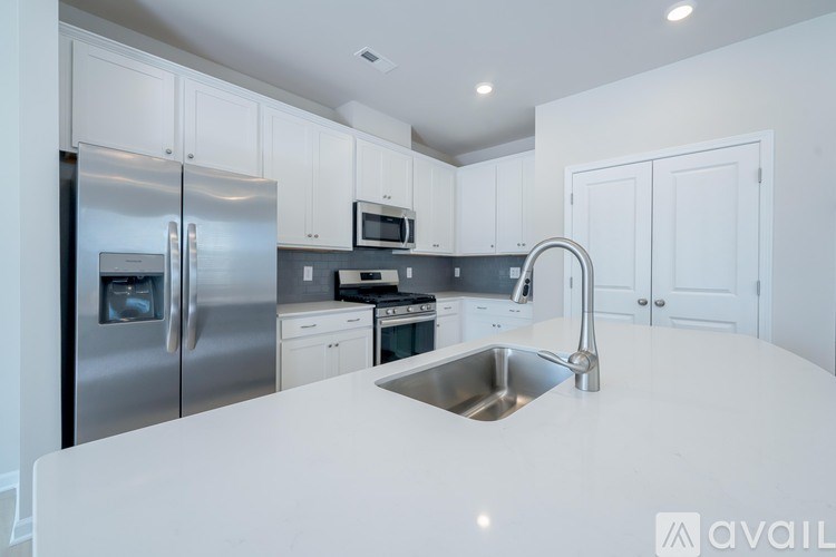 A modern kitchen with a stainless steel refrigerator, microwave, and oven.