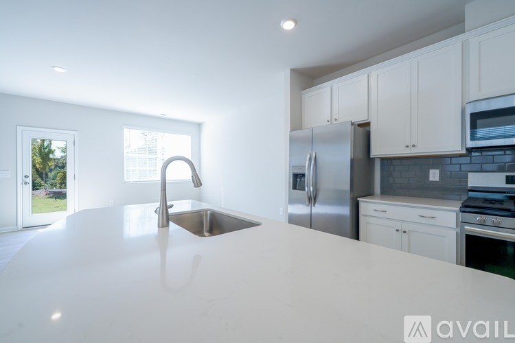 A kitchen with a white countertop and stainless steel appliances.