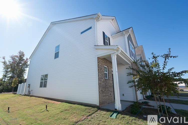 A white house with a blue sign that says "available" in front of it.