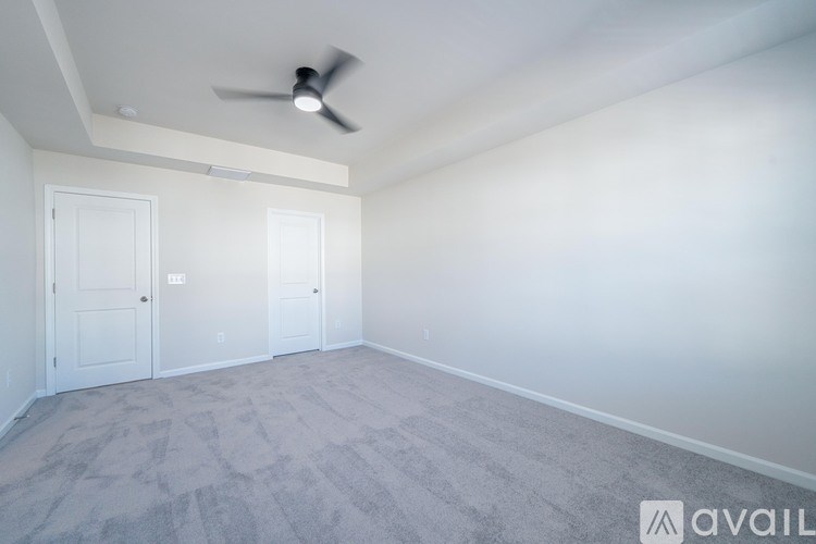 A room with a ceiling fan and carpeted floor.