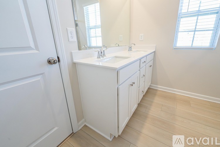 A white bathroom with a double sink and a large mirror.
