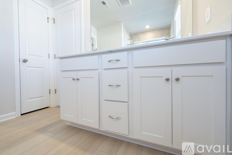 A white cabinet with a mirror above it.