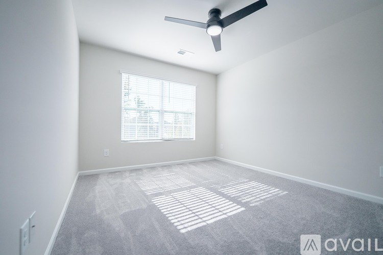 A room with a fan and a window with blinds.