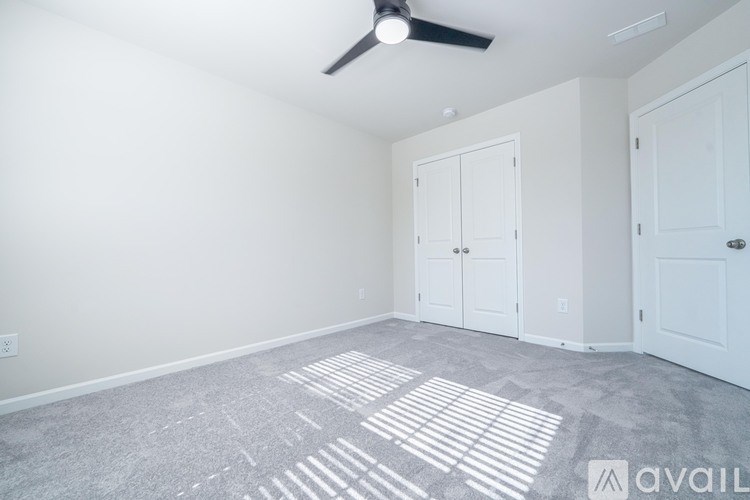 A room with a fan and two doors.