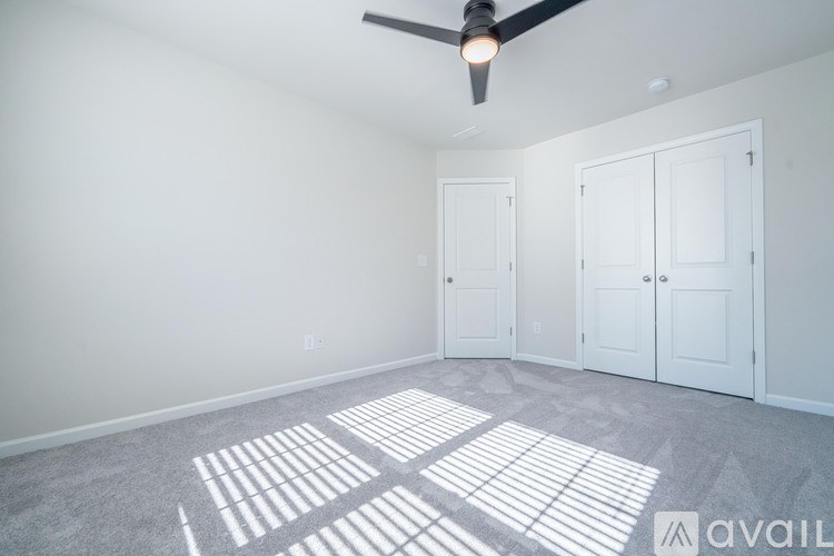 A room with a ceiling fan and two doors.