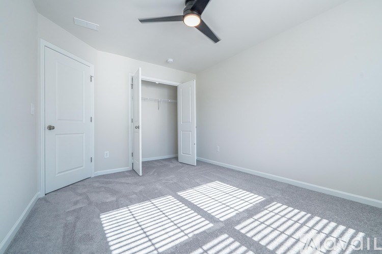 A room with a ceiling fan and two doors.