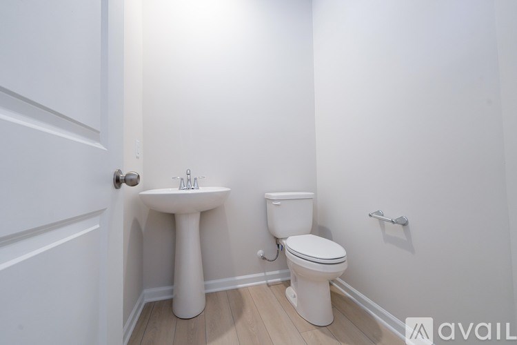A white bathroom with a toilet and pedestal sink.