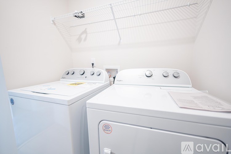 Two white front loading washing machines in a laundry room.