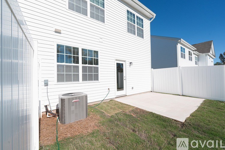 A house with a white siding and a grey air conditioning unit outside.