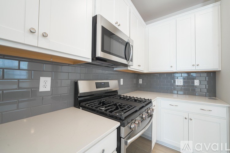 A kitchen with white cabinets and a black stove top oven.