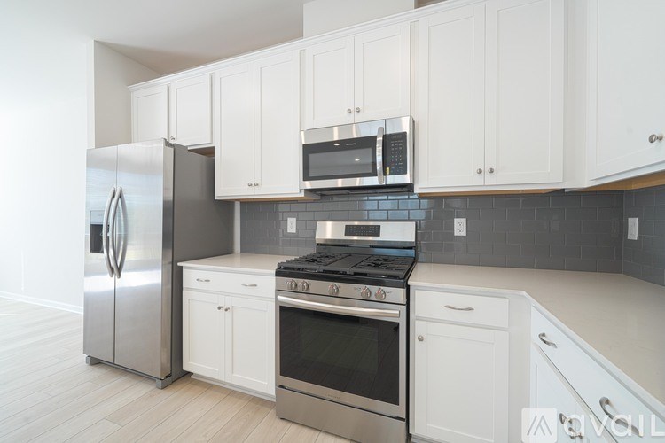 A kitchen with white cabinets and stainless steel appliances.