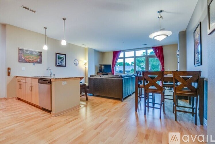 A kitchen with wooden floors and a dining area with chairs.