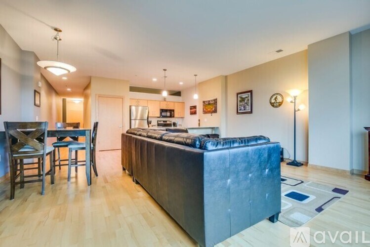 A living room with a grey couch and a wooden floor.