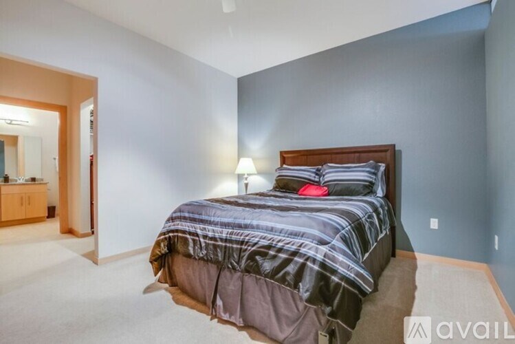 A bedroom with a bed covered in a striped comforter.