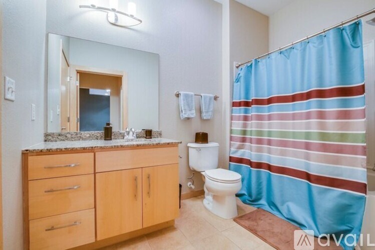 A bathroom with a toilet, sink, and a striped shower curtain.