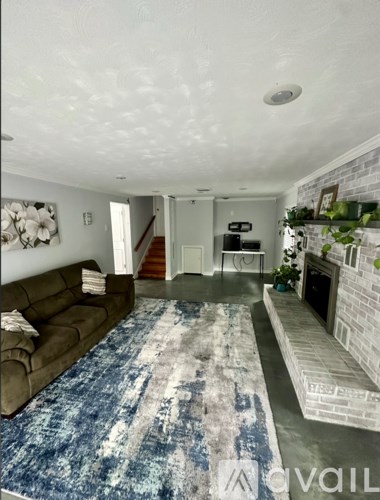 A living room with a couch and a rug.